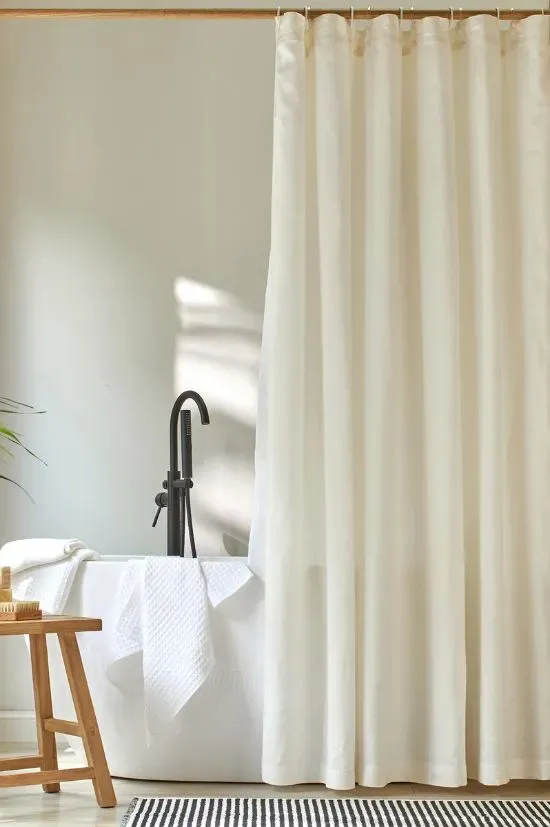 Stylish shower curtain installed in small apartment bathroom
